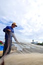 A fisherman is removing anchovies fish from his fishing net to begin a new working day in Ly Son island Royalty Free Stock Photo