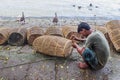 Fisherman repairing fishing cage on the riverbank