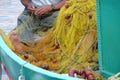 Fisherman repairing fishing net in Panormitis. Symi island, Greece.