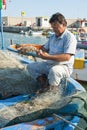 Fisherman repairing fishing nets