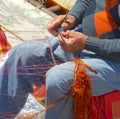 Fisherman repairing the fishnet. Royalty Free Stock Photo