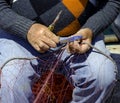 Fisherman repairing a fishing net