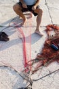 Fisherman reparing fishing net