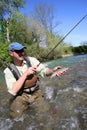 Fisherman in river catching trout Royalty Free Stock Photo