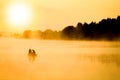 Fisherman on the river in the fog in the park on the nature