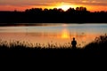 Fisherman with a rod fishing at sunset Royalty Free Stock Photo