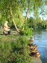 Fisherman and row of wild ducks on lakeshore Royalty Free Stock Photo