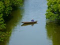 A fisherman rowing on a river