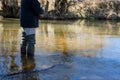 Fisherman with rubber boots trout fishing in a creek on a sunny day. Angler casting artificial bait in a river Royalty Free Stock Photo