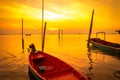 Fisherman`s boat floating in the sea near bamboo pole at sunset in Thailand. Royalty Free Stock Photo