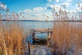 Fisherman\'s bridge and yellow brushwood and reeds near the blue water of the lake, Guyva river in Andrushivka, Ukraine Royalty Free Stock Photo