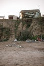 Fisherman`s house on the abrasive shore of the sea. At the foot of the cliff lies fishing tackle Royalty Free Stock Photo