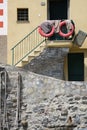 Fisherman`s house with lifebuoys and ropes. Stairway with ancient stone wall