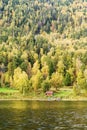 Fisherman`s house on the shore of a mountain lake, with a marina and a motor boat Royalty Free Stock Photo