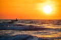 Fisherman sailing with his boat on beautiful sunrise over the sea Royalty Free Stock Photo