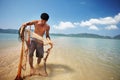 Fisherman, sea and man with net working, nature and labor with fishing in Thailand and tropical island location. Ocean Royalty Free Stock Photo