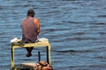 Fisherman on a self-made platform with fishing tackle and rods