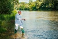 Fisherman senior rich businessman in suit caught a fish. Man fishing on river. Royalty Free Stock Photo