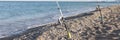 Fisherman setting up fishing rods on sea beach, seaside landscape Royalty Free Stock Photo