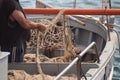 Fisherman is settings up his fishing net on the boat in the sea