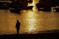 Fisherman silhouette on the beach at colorful sunset, fishing background