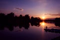 Fisherman silhouette on sunset background. Friends fishers enjoy fishing on river dock. Royalty Free Stock Photo