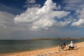 Fisherman sits with fishing rods on the seashore