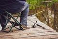 A fisherman sits on an old wooden bridge and catches fish