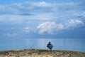 Fisherman sitting relaxed with a blue sky