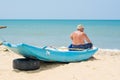 Fisherman sitting on the small wooden boat at the beach