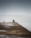 Fisherman sleeping on the pier on a foggy day at sea Royalty Free Stock Photo