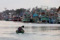 A fisherman and a small fishing boat are passing by the marina after returning from their evening fishing trip.