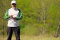 Fisherman with spinning rod and focus at artificial lure