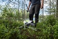 Fisherman with a spinning rod in hands stands near a new, rubber inflatable boat and oars. Preparing for fishing. Active