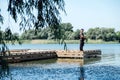 Fisherman with spinning rod on the lake. fisherman with spinning in his hands catching fish at sun day. Fisherman with Royalty Free Stock Photo