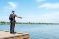 Fisherman with spinning rod on the lake. fisherman with spinning in his hands catching fish at sun day. Fisherman with Royalty Free Stock Photo