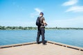 Fisherman with spinning rod on the lake. fisherman with spinning in his hands catching fish at sun day. Fisherman with Royalty Free Stock Photo