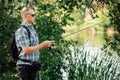 Fisherman with spinning rod on the summer lake. fisherman with spinning in his hands catching fish at sun day. Fisherman Royalty Free Stock Photo