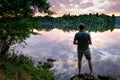 Fisherman standing on the banks of Vltava at beautiful sunset, fishing concept