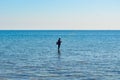 A Fisherman Standing Fishing In The Rocky Seashore On Sunny Day Royalty Free Stock Photo