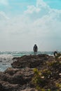 Fisherman standing on a jutting rock overlooking the sea Royalty Free Stock Photo