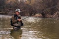 Fisherman standing in river when fishing for trout Royalty Free Stock Photo