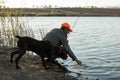 Fisherman standing on the riverside and trying to catch a fish. Sport, recreation