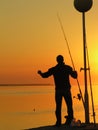 A fisherman standing by the sunset Royalty Free Stock Photo