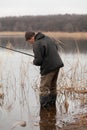 fisherman stands in the water and catches fish