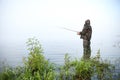 Fisherman stands in the water on the lake