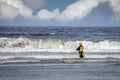 A fisherman surf fishing in the ocean waves Royalty Free Stock Photo