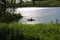 The fisherman swims by boat on the lake. Royalty Free Stock Photo