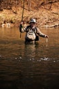 Fisherman takes a hand caught grayling from river