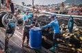 A fisherman taking the fish off a boat at Ban Bang Saray Fish Bridge, Thailand